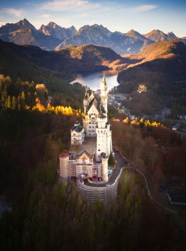 Aerial view of Neuschwanstein Castle with Alps mountains, Bavaria, Germany Aerial view of Neuschwanstein Castle with Alps mountains, Bavaria, Germany