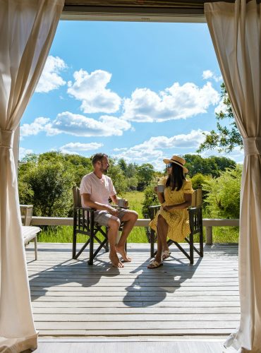 couple on safari in South Africa, Asian women and European men at a tented camp lodge during safari couple on safari in South Africa, Asian women and European men at a tented camp lodge during safari